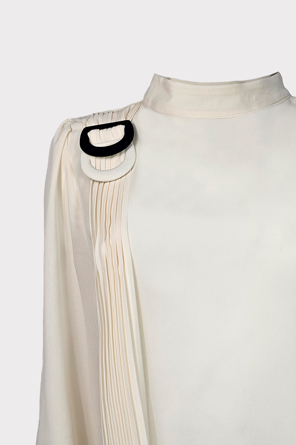 Blusa con fibbia decorativa
